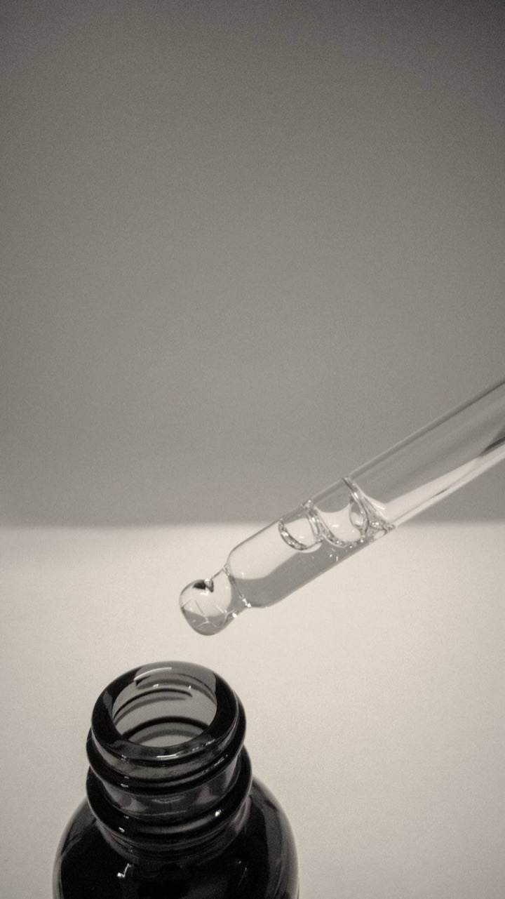 Açık zeminde serum şişesinin üstünde duran cam damlalık
